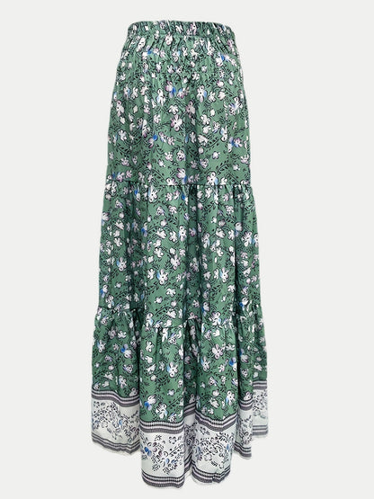 Tiered printed elastic waist skirt in green with floral design, ruched detailing, made of 100% polyester.