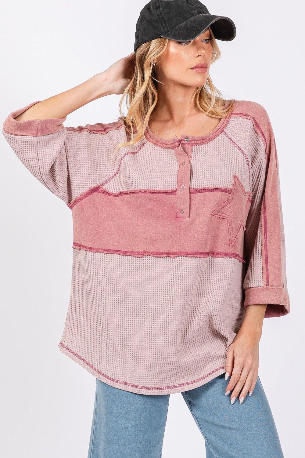 Star applique patch exposed seam waffle knit top in pink, styled with rolled sleeves and casual fit.