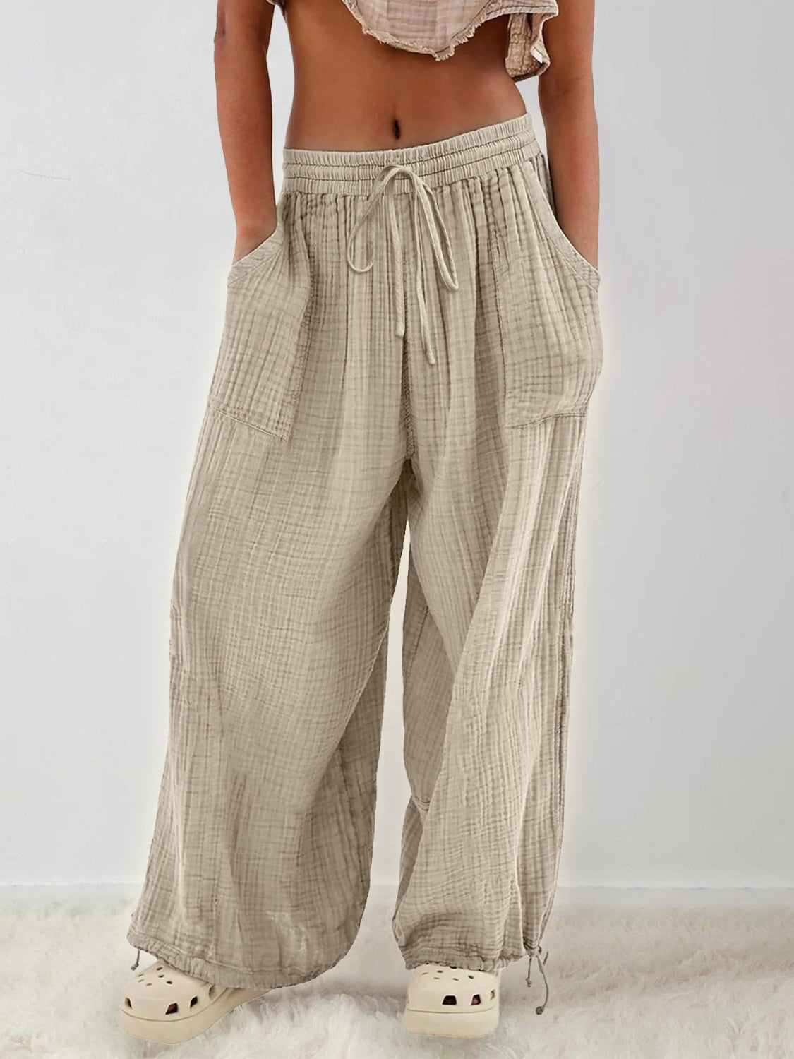 Textured tied pants with pockets in beige, featuring a comfortable fit and opaque material.