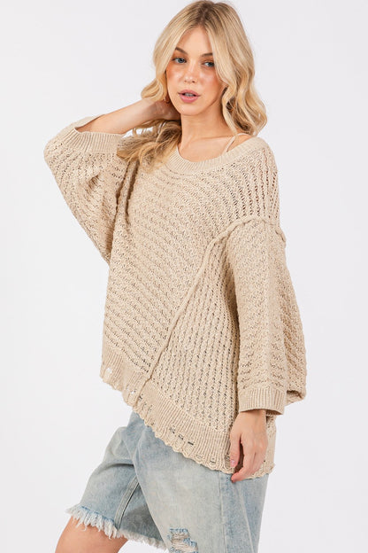 Distressed asymmetrical open stitch sweater with half sleeves and round neckline.