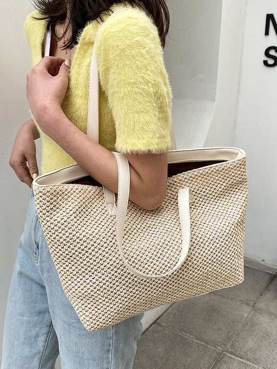 Medium solid color woven tote bag with handles, fashionable design.