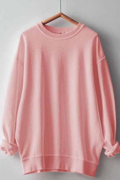 Round neck long sleeve pink sweatshirt on hanger.