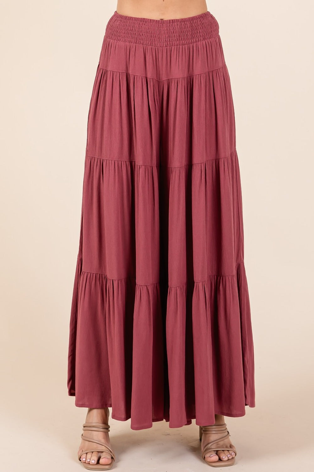 Tier detail smocked elastic waist wide leg pants in lightweight crepe fabric with tiered design and side pockets.