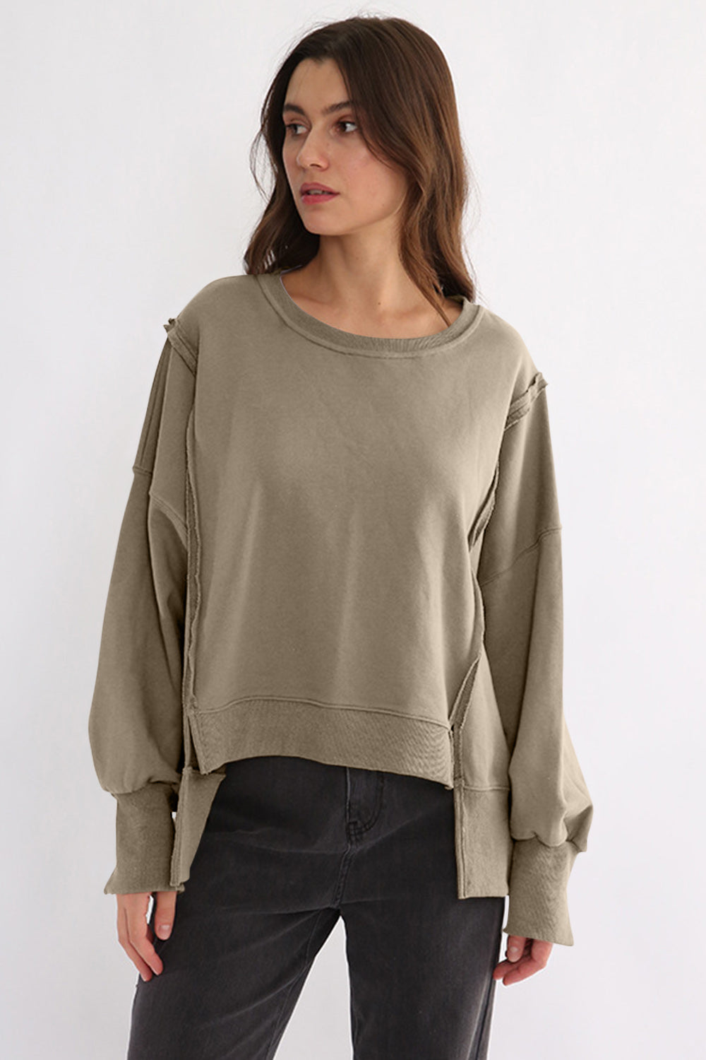 Exposed seam high-low long sleeve sweatshirt in olive tone, made of 100% cotton with slits.