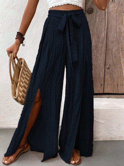 Honey Tied Slit Wide Leg Pants with a flowy design in black, featuring a waist tie and side slits.