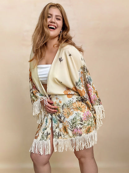 Plus size fringe printed open front cardigan with floral design and fringe detailing, worn by smiling woman.