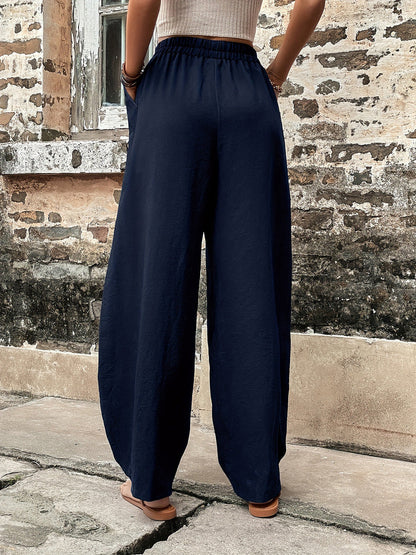 Elastic waist pants with pockets, polyester and spandex, shown in opaque black, featuring a relaxed fit.