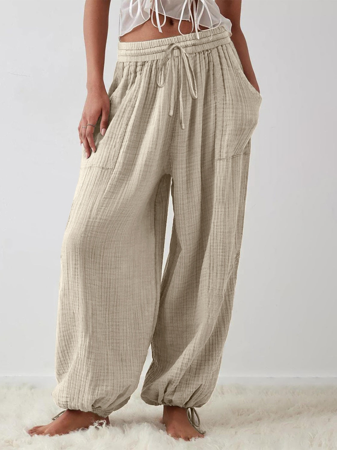 Textured tied pants with pockets, comfortable fit, polyester-spandex blend.