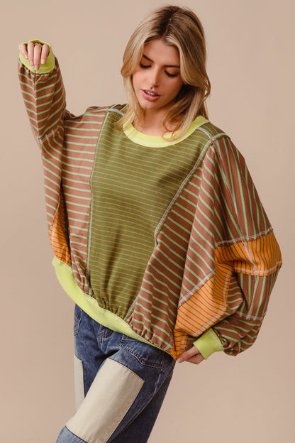 Colorful striped round neck sweatshirt with exposed seams and vibrant color blocks.