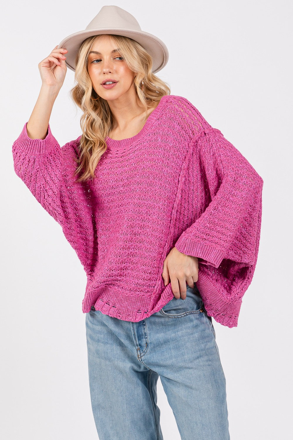 Distressed asymmetrical open stitch sweater in magenta with half sleeves and round neckline.