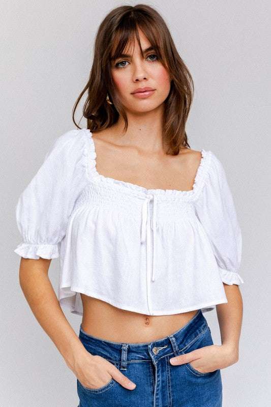 Puff Sleeve Smocked Detail Flared Crop Top with front bow tie, white, model wearing jeans.