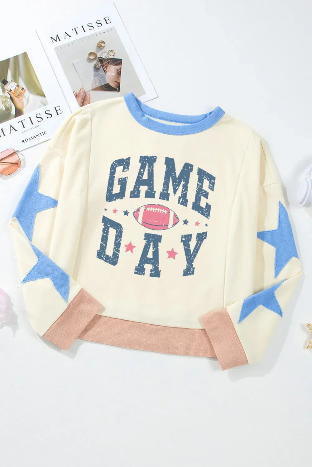 GAME DAY Star Patch Round Neck Long Sleeve Sweatshirt with football graphic and blue star sleeves.