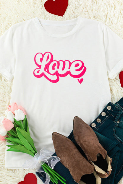 LOVE Round Neck Graphic T-Shirt with pink lettering, white fabric, styled with boots and tulips.