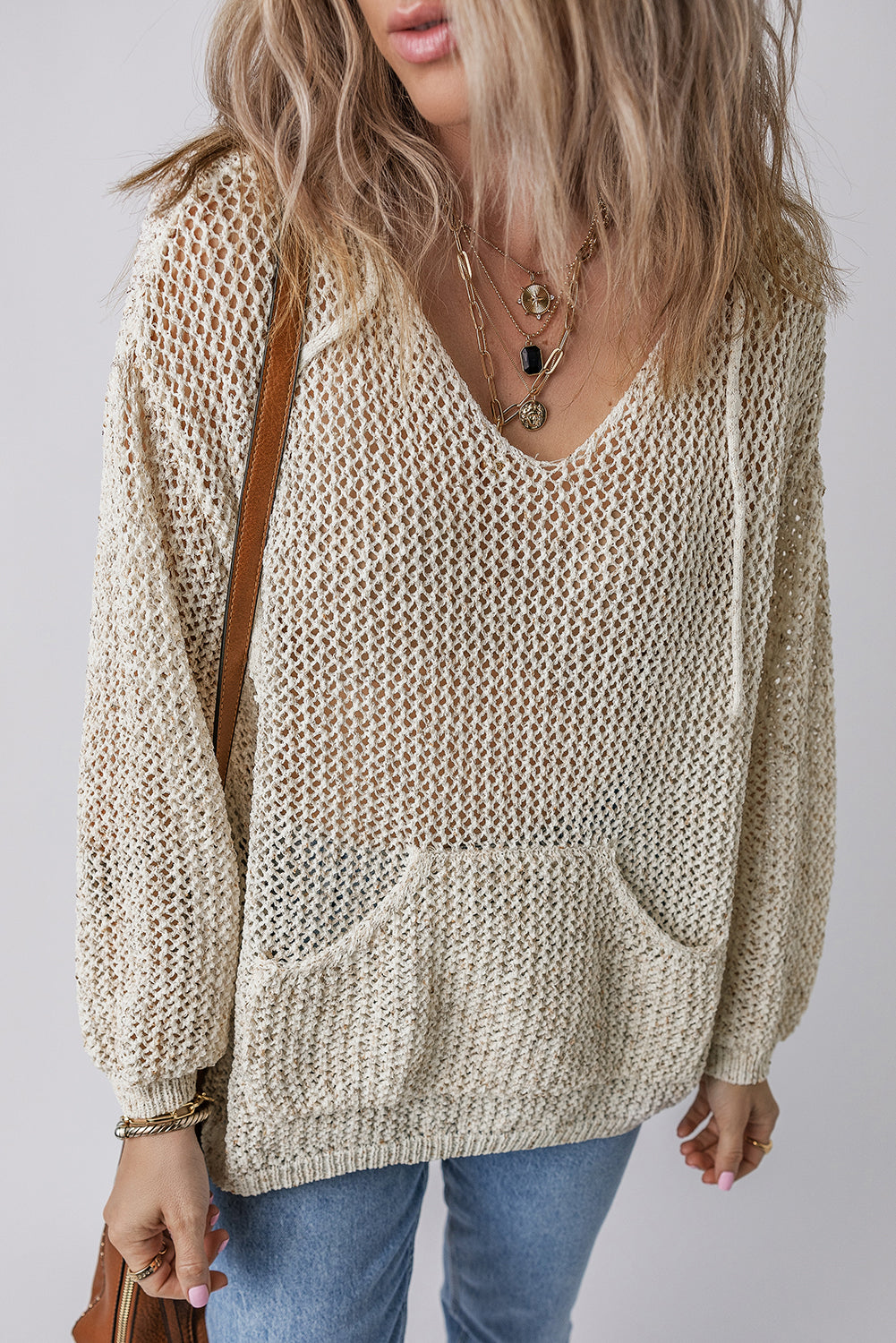 Openwork dropped shoulder hooded knit top with cutout design being worn.