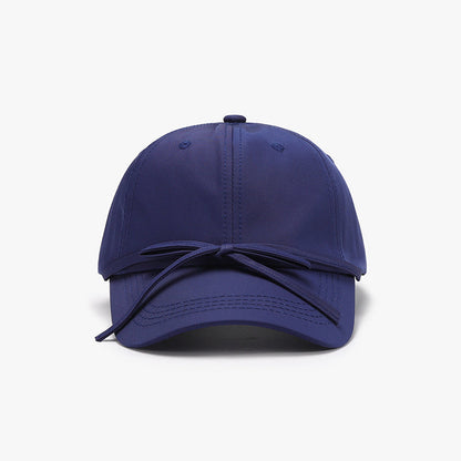 Navy blue cotton baseball cap with tied bow detail for women.