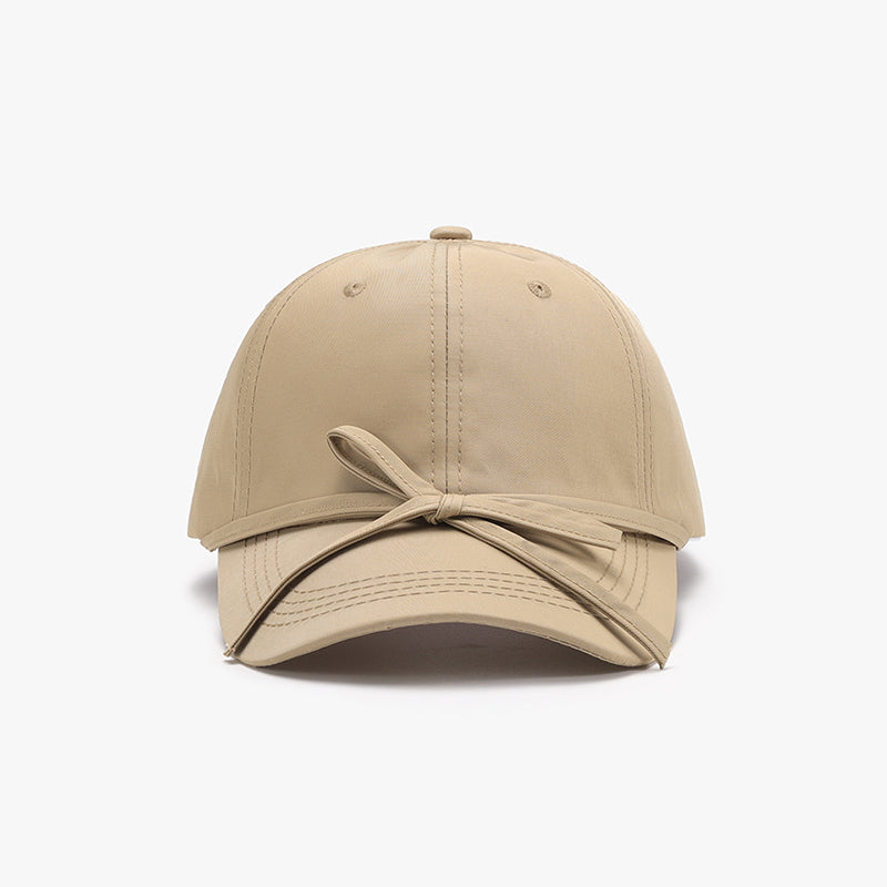 Beige cotton baseball cap with tied bow design for women.