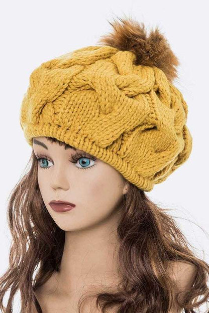 Large yellow cable knit beret beanie with faux fur pom.