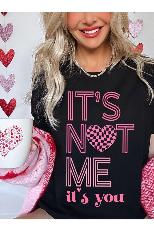 It’s Not Me It’s You Valentine's Day Graphic T-Shirt with pink lettering and heart design, casual unisex fit.