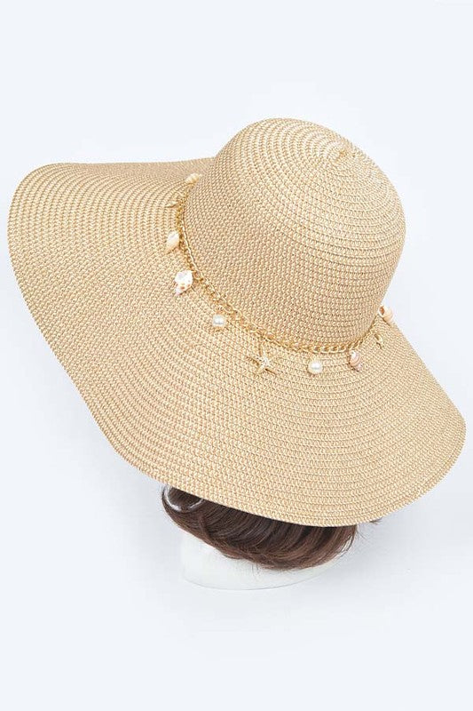 Floppy sun hat with pearl and shell charms, made of faux straw.