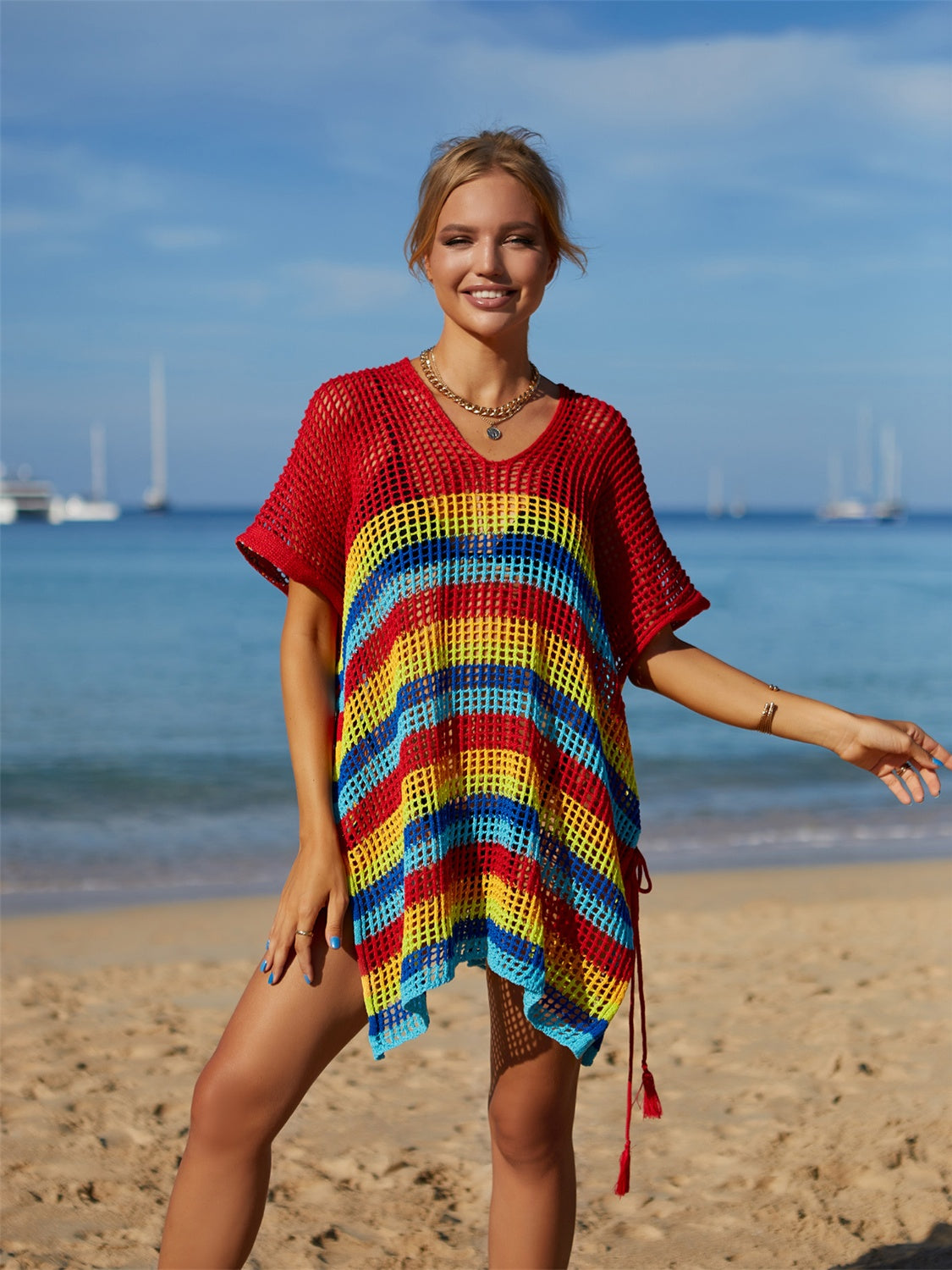 Rainbow cutout striped swim cover up with slit detail on a beach.