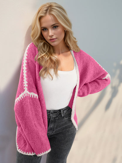 Pink super cozy open cardigan with white trim, worn by a woman in a casual outfit.