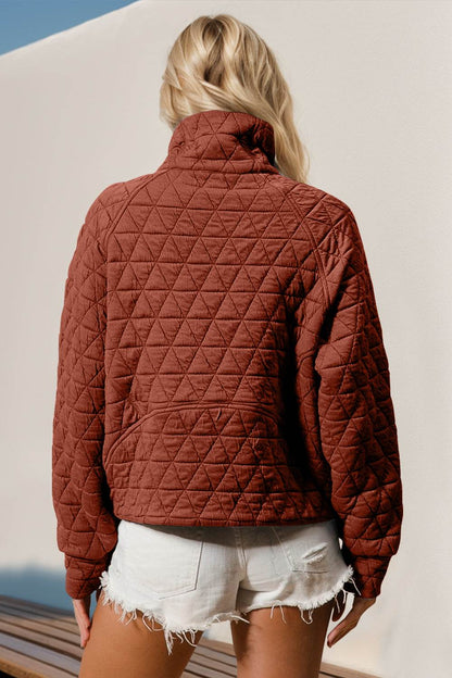 Rear view of a woman wearing a quilted half zip long sleeve sweatshirt with pocket, showing the back design.