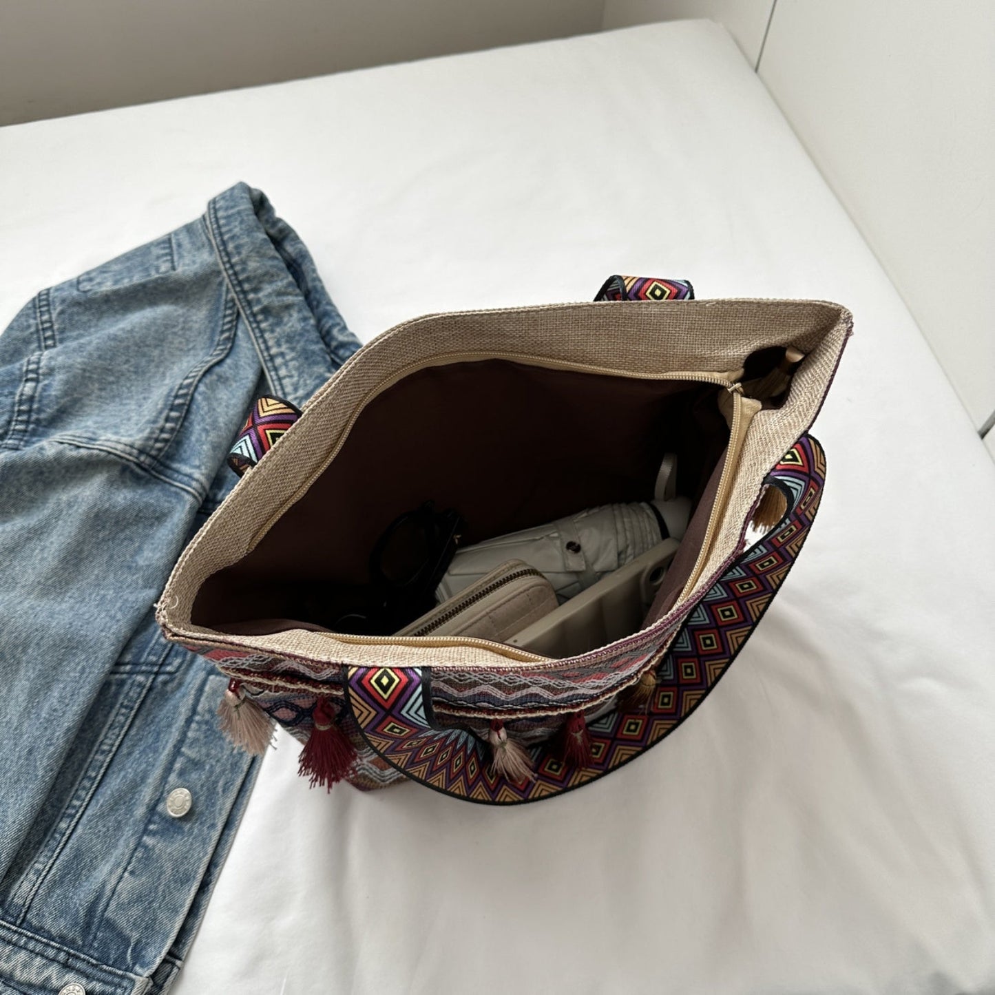 Boho tote bag with chic print and tassel details displaying interior space.