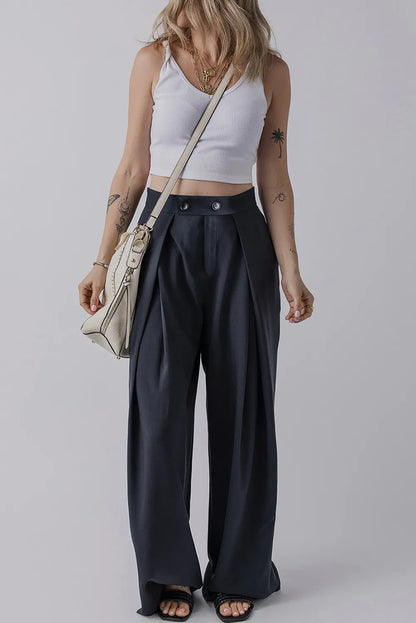 Wide leg pants with pockets in black, worn by a model with a white tank top.