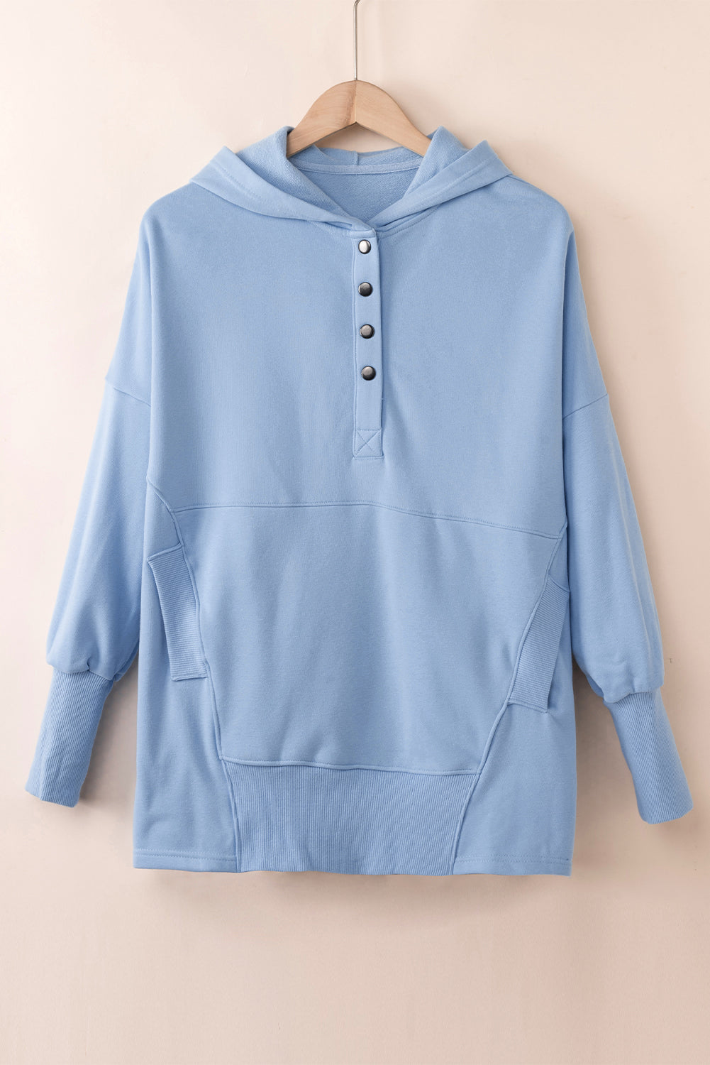 Quarter-snap dropped shoulder hoodie in blue with buttoned front and pockets.