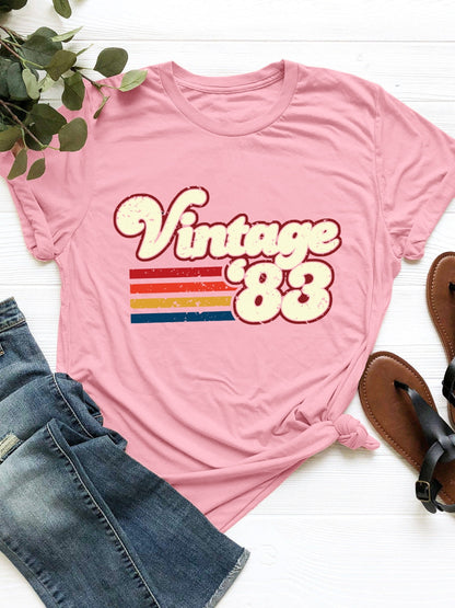 Vintage '83 Graphic T-Shirt in pink with retro design, paired with jeans and sandals.