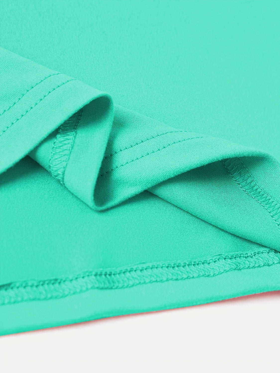 Close-up of folded Vintage '83 Graphic T-Shirt in green polyester fabric.