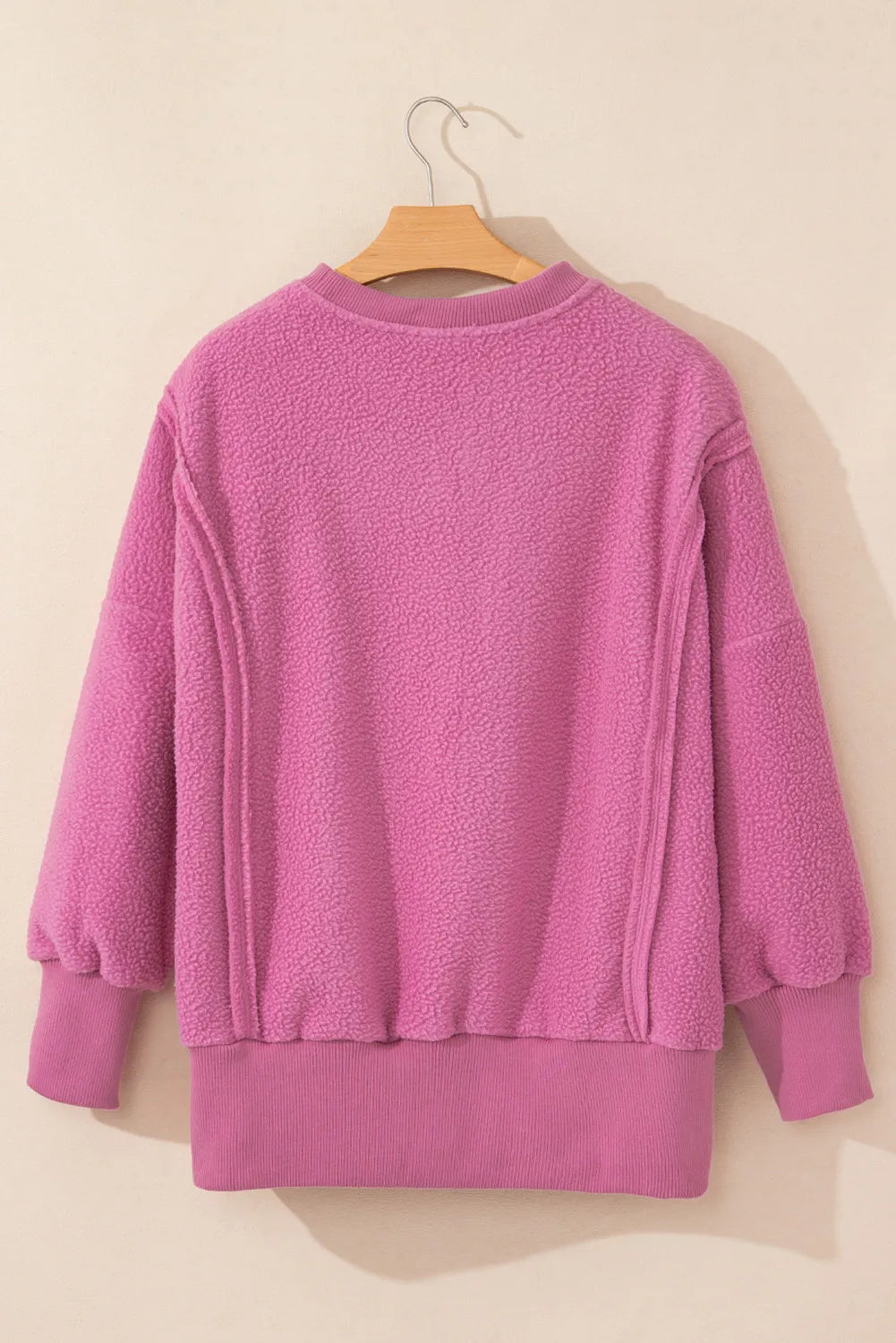 Slit Round Neck Long Sleeve Sweatshirt in pink with exposed seams and high-low design.