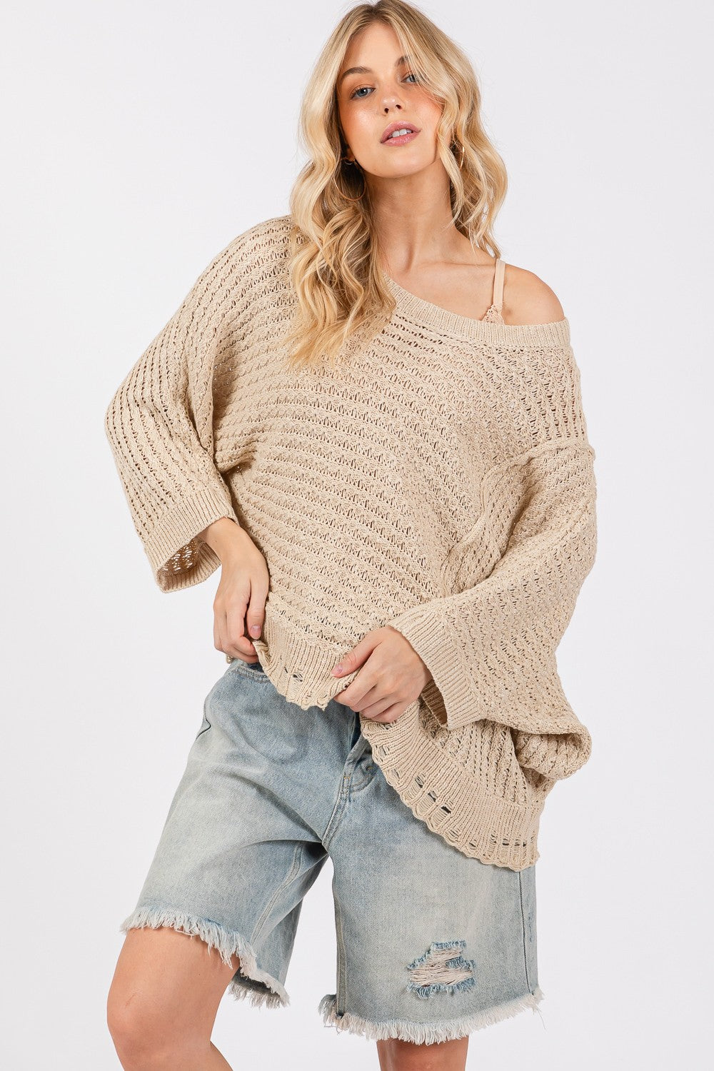 Distressed asymmetrical open stitch sweater with half sleeves and round neckline.