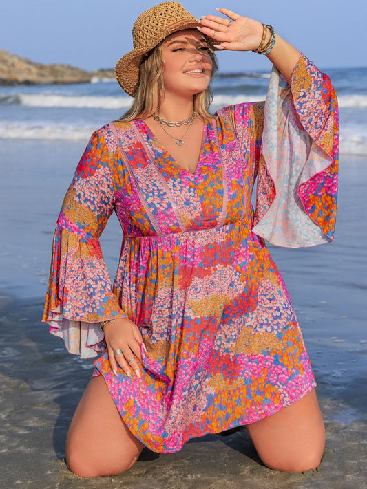 Plus Size Ruched Printed Long Sleeve Dress in vibrant colors, floral pattern, beach setting.