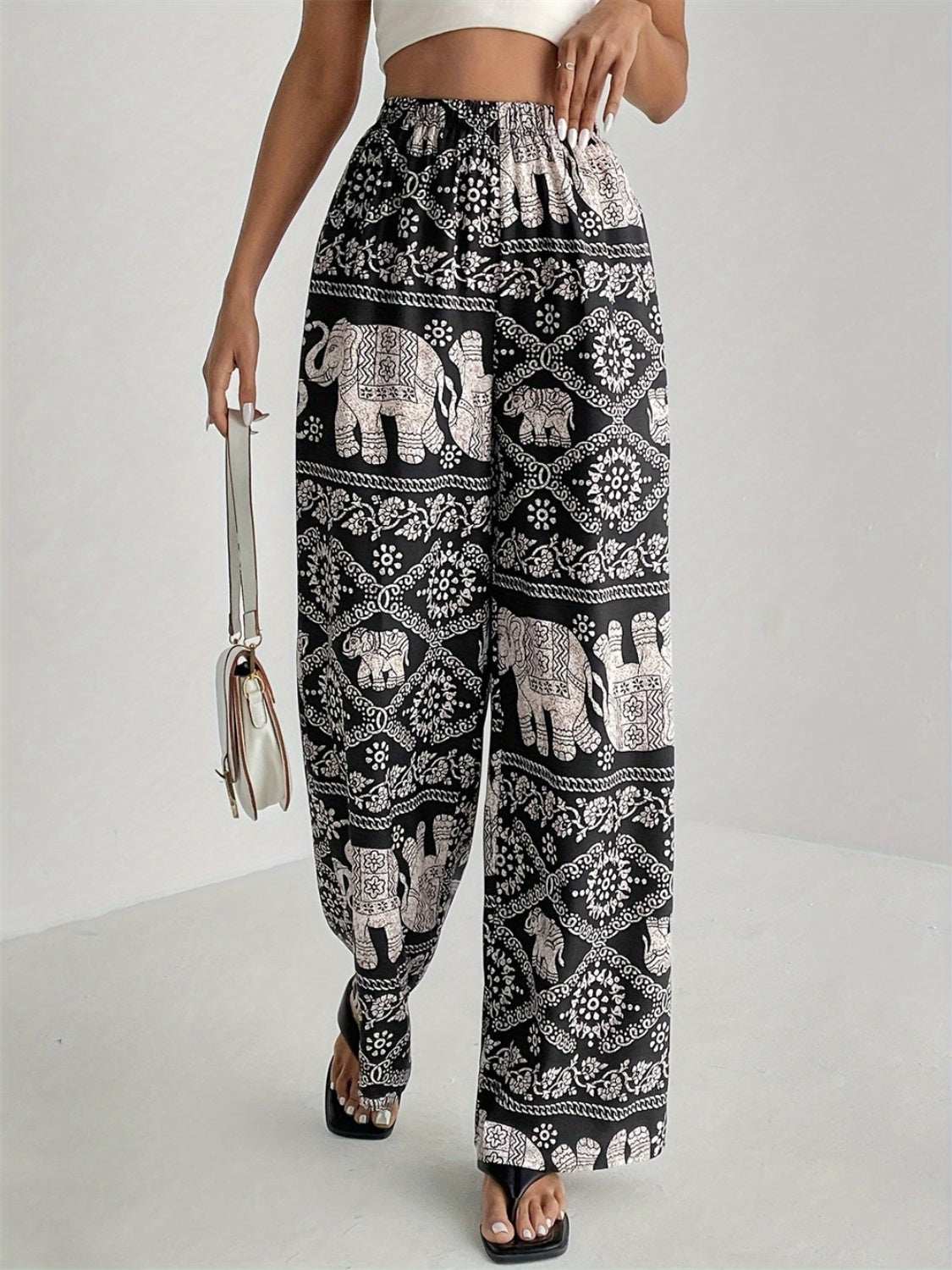 Printed wide leg elastic waist pants with elephant pattern design.