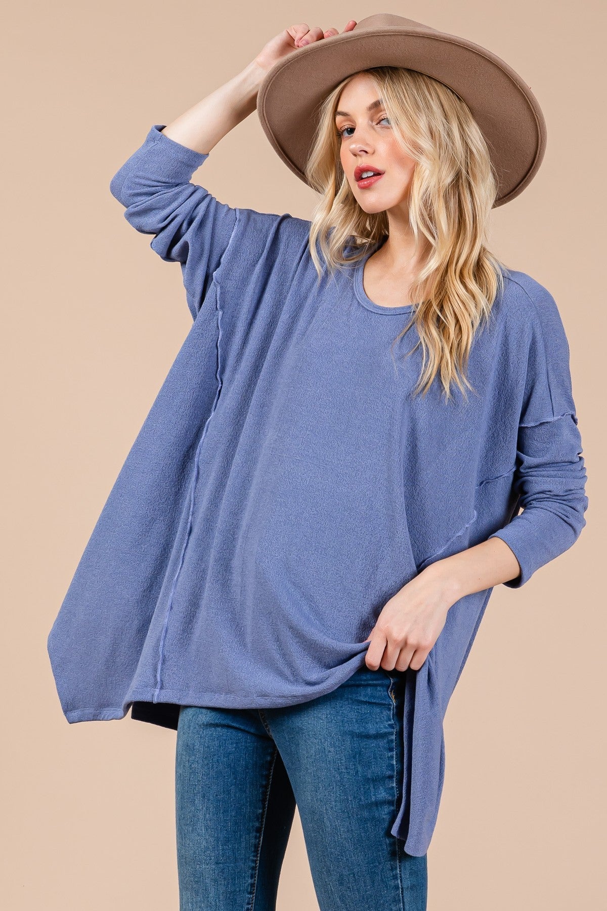 Oversized asymmetrical long sleeve top in soft knit fabric with drop sleeve design and hi-low hem.