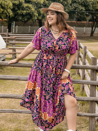 Plus Size Printed V-Neck Flutter Sleeve Midi Dress in vibrant floral pattern, outdoor setting.