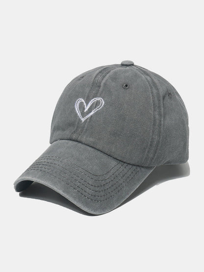 Embroidered heart washed cotton baseball cap in gray color with adjustable strap.