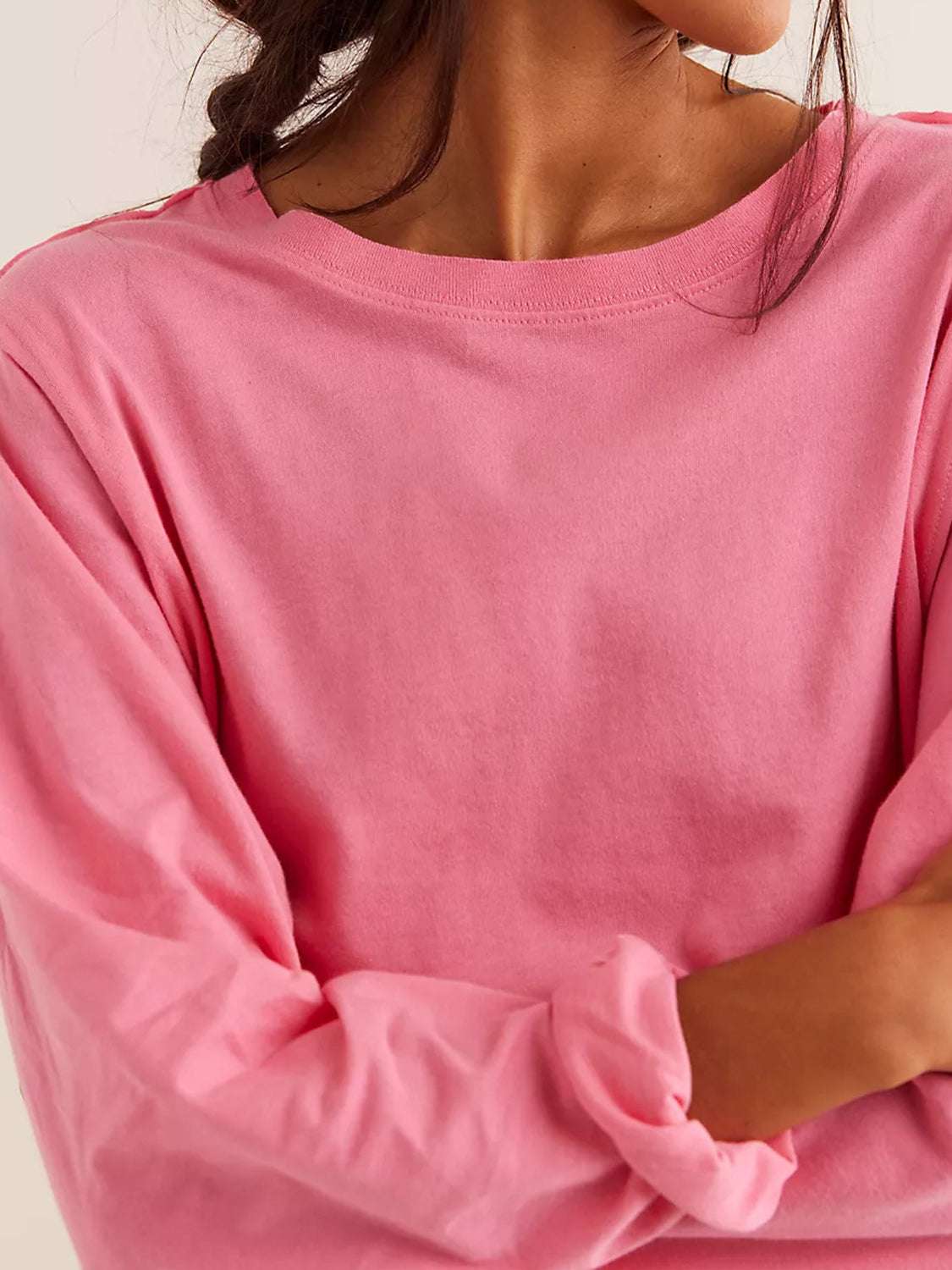 Pink round neck long sleeve cropped tee for women, casual and stylish.