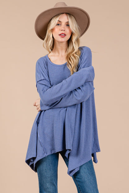 Oversized asymmetrical long sleeve top with hi-low hem in blue fabric.