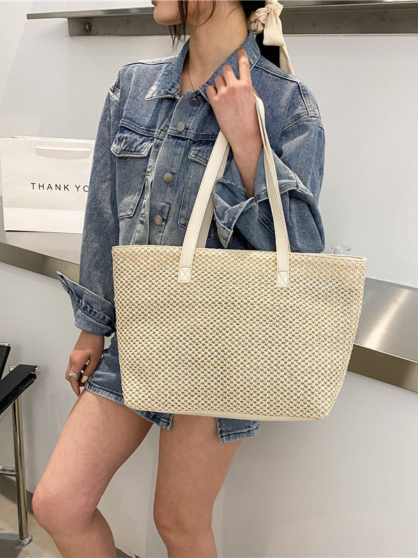 Medium solid color woven tote bag in beige with handles.