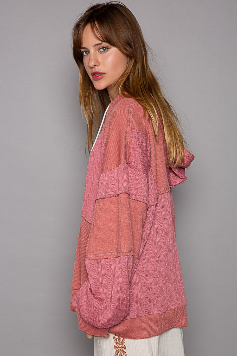 Exposed Seam Hooded Knit Top with balloon sleeves and overlock stitch details in pink.