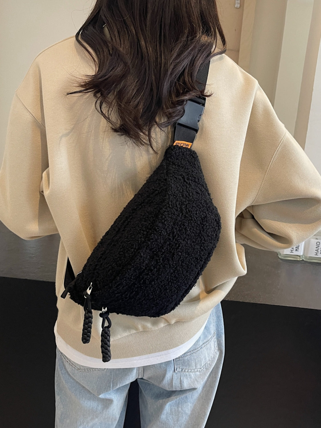 Medium black Sherpa crossbody bag with adjustable strap, 12.6" length, 4.7" width, 6.3" height.