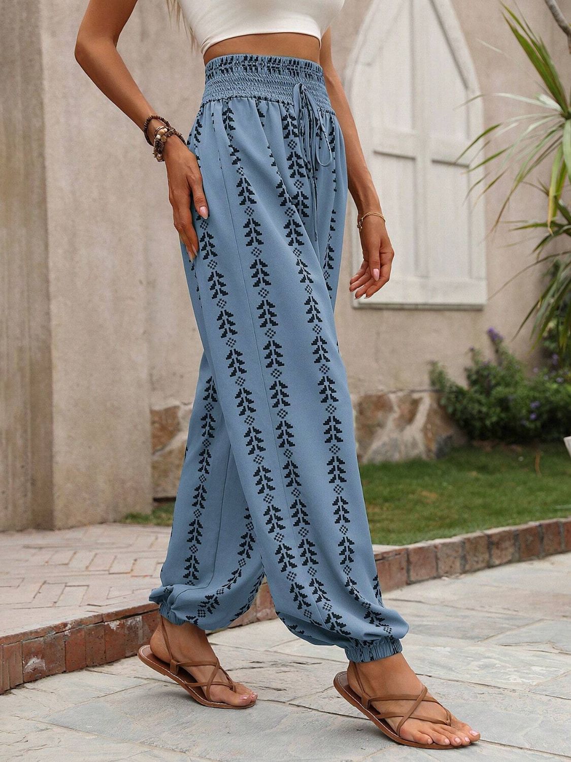 Tied printed high waist pants in blue with black patterns, made of 100% polyester.