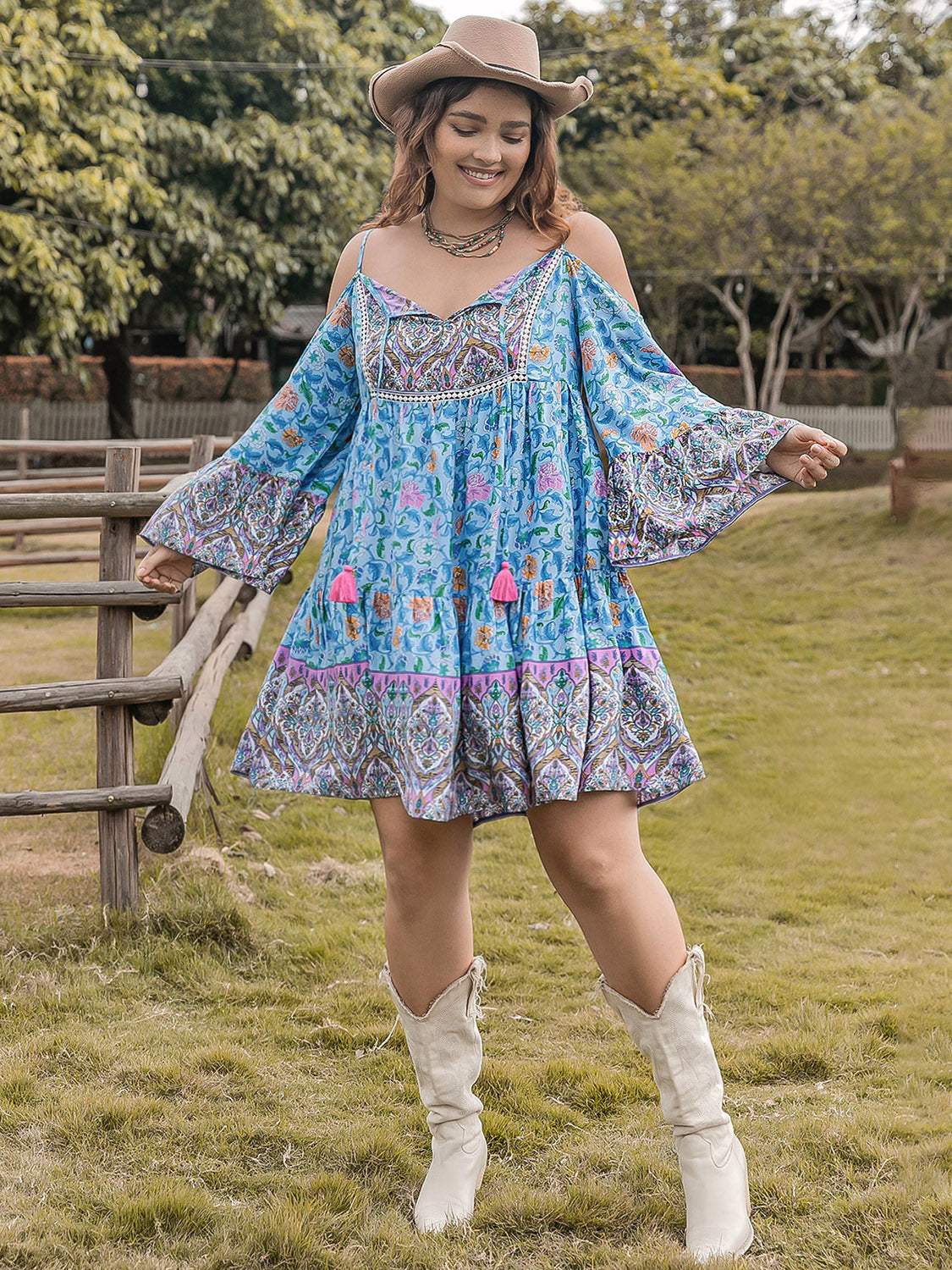 Plus size printed long sleeve mini dress in blue with colorful patterns, worn by a model outdoors.