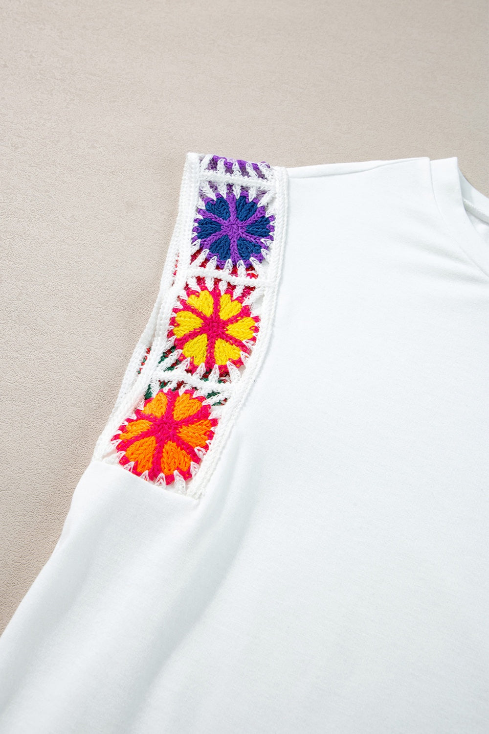 Boho colored cap sleeve top with colorful embroidery detail.