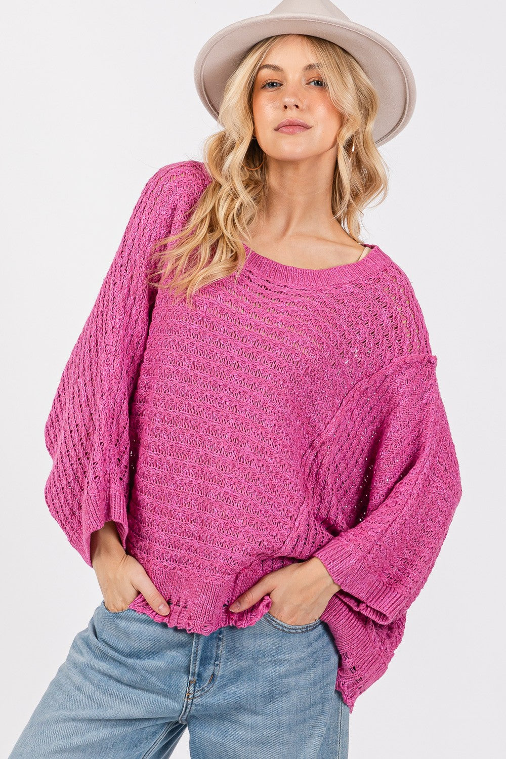 Distressed asymmetrical open stitch sweater in magenta with half sleeves and round neckline.