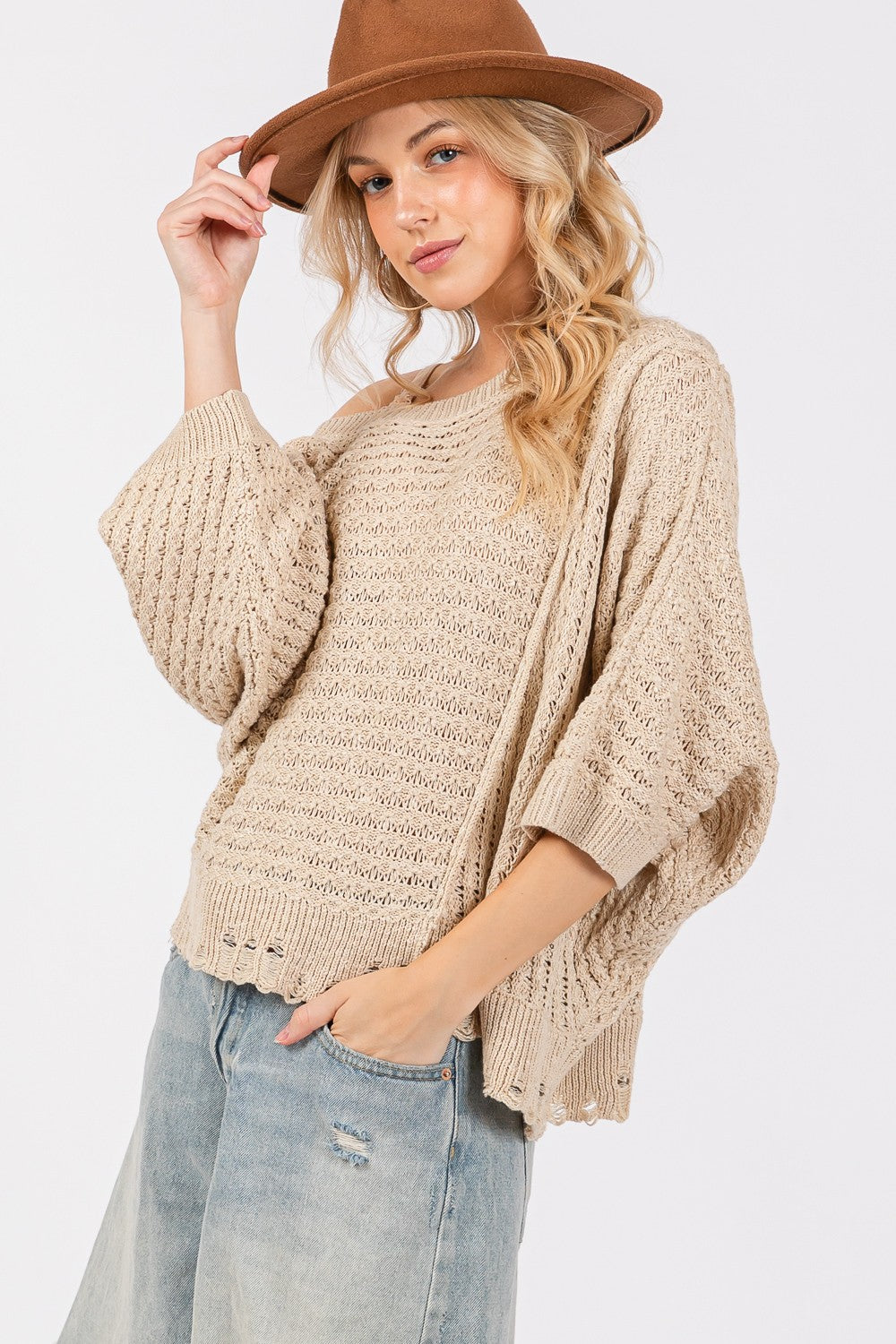 Distressed asymmetrical open stitch sweater with half sleeves and a relaxed fit.