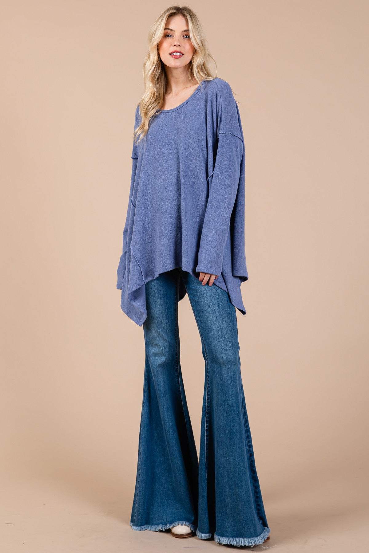 Blue oversized asymmetrical long sleeve top with hi-low hem, relaxed fit model.