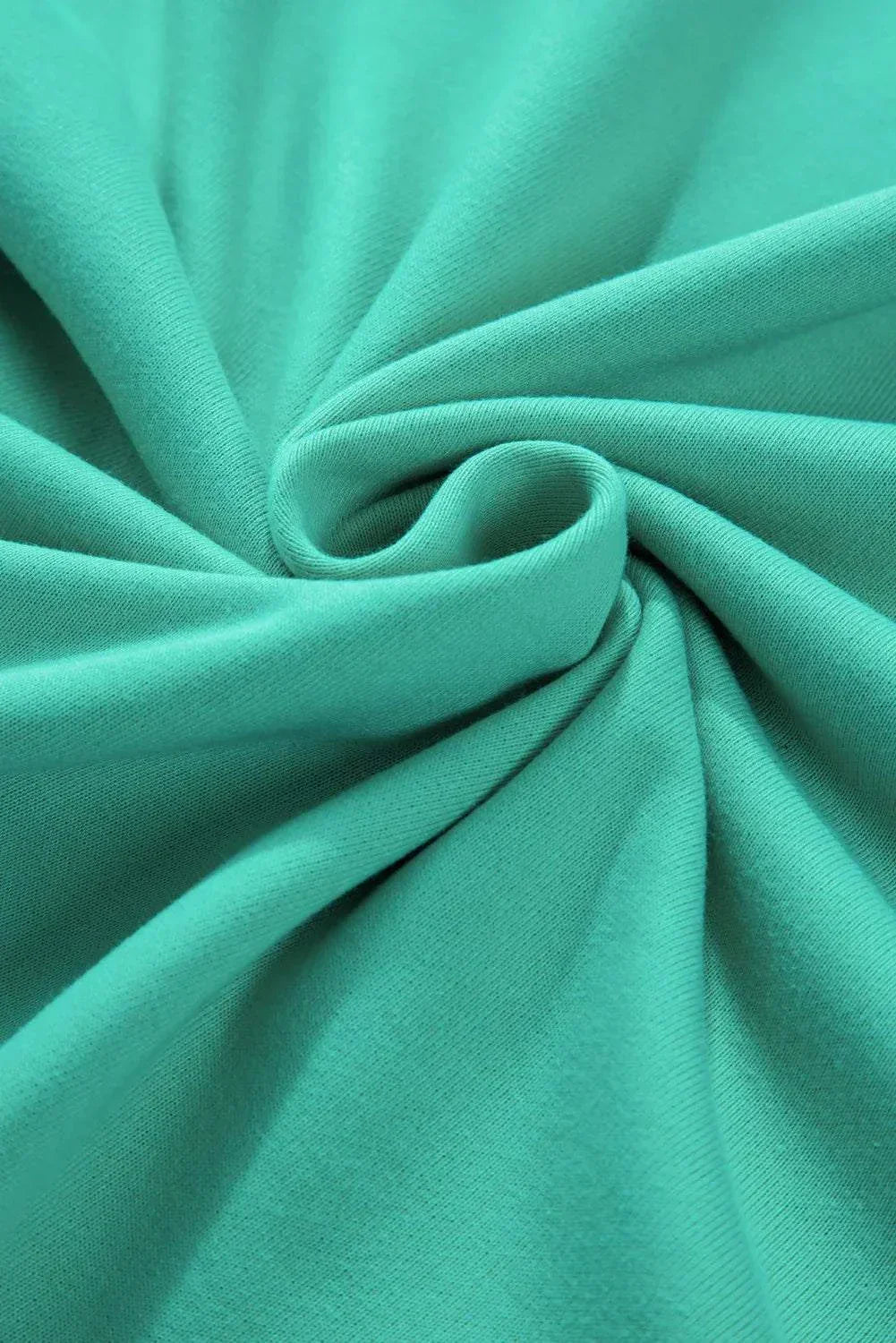 Close-up of teal fabric texture from plus size exposed seam color block long sleeve sweatshirt.